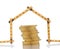 A carpenters ruler in the shape of a house with a stack of gold coins