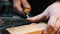 Carpentry indoors - a woodworker cutting out the recess on the wooden block with a chisel