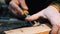 Carpentry - a woodworker cutting out the recess on the wooden block with a chisel