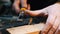 Carpentry in the workshop - a woodworker cutting out the recess on the wooden block with a chisel