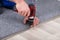 Carpet Fitter Installing Carpet With Wireless Screwdriver