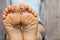 The carpet at home on the floor bare feet of a young girl with a smile and sadness drawn in pencil on her fingers, good mood