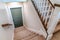 Carpeted U shaped staircase that leads down to the basement door of a home