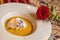 Carrot and chestnut creamy soup served on white plate with wine glass, romantic time on valentines day