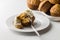 Carrot cinnamon cake muffin with yogurt on white serving plate with muffins in background isolated on white