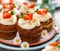 Carrot cupcakes with mascarpone cream decorated with marzipan carrots on a plate.