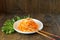 Carrot Korean meat salad with chopsticks on wooden oak table