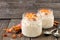 Carrot overnight oats with nuts and raisins in mason jars on rustic wood