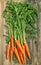 Carrot roots over rustic wooden background