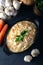 Carrot tarator in ceramic bowl with vegetable on dark background.