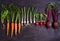 Carrots, beet, radishes, onions, garlic, spinach - root vegetables on a black wooden background. Summer farm vegetables