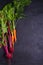 Carrots and beet - root vegetables on a black background. Summer farm vegetables. Food background, layout, room for text.