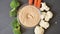 Carrots, cauliflower and broccoli florets appearing around a bowl of hummus