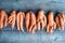 Carrots with deformed twisted forked roots distorted and crooked on wooden background