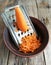 Carrots grated and old metal grater in a clay bowl