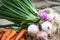 Carrots and onions on table background and woven sack