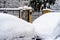 Cars covered with snow from the first snow fall of the year. Winter concept, snowy cars parked on the street, deep layer of snow