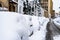 Cars covered with snow from the first snow fall of the year. Winter concept, snowy cars parked on the street, deep layer of snow