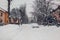 Cars covered with snow during snowfall in city. Automobiles stuck in heaps after winter blizzard