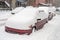 Cars covered in snow during snowstorm