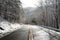 Cars on descent on the snowy mountain asphalt road with two lanes.