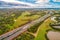 Cars driving on Eastlink Highway among parklands near Tirhatuan Wetlands in Melbourne.