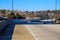 Cars driving on a freeway off ramp with lush green trees and bare winter trees and gorgeous blue sky in downtown Atlanta