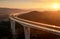 Cars driving on a highway viaduct at sunset