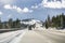 Cars driving on I80 interstate through the Sierra mountains close to lake Tahoe on a sunny winter day; the road has been cleared