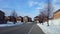 Cars driving, people walking, and plane flying above residential suburban houses. Stopping and going vehicles on street