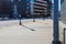 Cars driving on a street lined with tall black light posts on a smooth sidewalk and glass buildings in downtown Atlanta