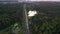 Cars of freight train passing to a distance at the double line railway in lakes and forests of Karelia, Russia. Aerial view