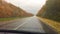 Cars go on the road asphalt. autumn travel beautiful view forest, raindrops on the glass car blurred background slow