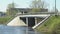 Cars going on bridge over small river on sunny day