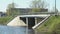 Cars going on bridge over small river on sunny day