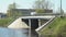 Cars going on bridge over small river on sunny day