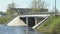 Cars going on bridge over small river on sunny day