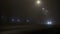 Cars with headlamps driving on a road in the mist at night, poor visibility due to haze