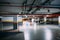 Cars in a large heated underground parking lot with lighting