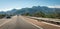 Cars motor down highway through coastal foothills and mountains of Spain.