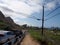 Cars parked along cliffside mountain highway at Makapuu with stretching blue pacific ocean