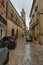 Cars parked on a cobblestone road on a rainy day