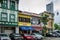 Cars parked in front of historic storefronts in modern Singapore