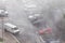 Cars parked at a parking lots near high-rise building under heavy shower rain and hurricane wind