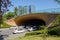 Cars parked at shady tunnel portal in city on sunny summer day