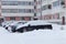 Cars in a parking lot in the city after a snowstorm. Russia, winter