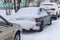 Cars in a parking lot in the city after a snowstorm. Russia, winter