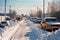 cars in parking lot with snow plow clearing path
