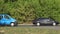 Cars slowly pass on the road in the morning traffic jam in front of bridges in the city against the background of green