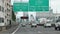 A cars slowly ride on a highway under the road sign